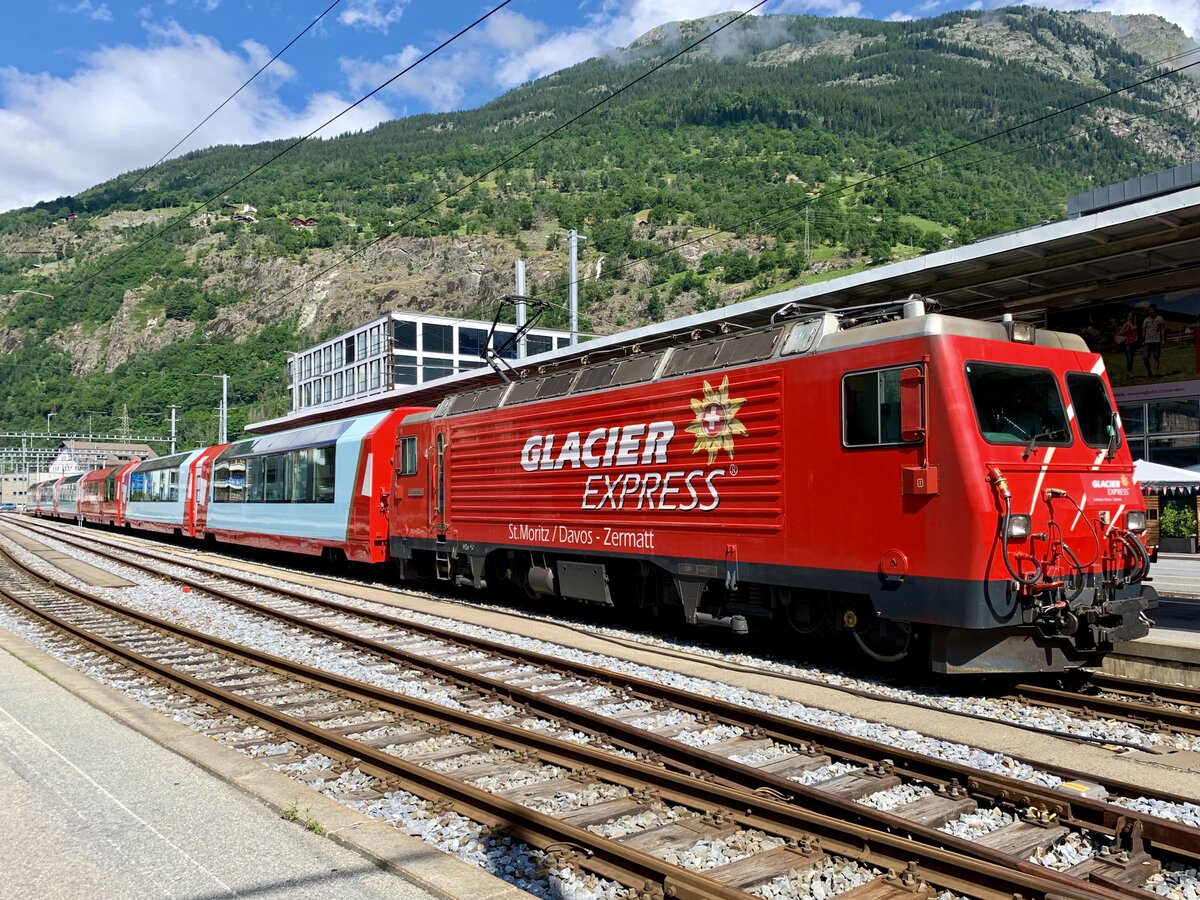 Die HGe 4/4 4  Täschhorn  mit einem Glacier Express am 23.6.21 im Bahnhof Brig.